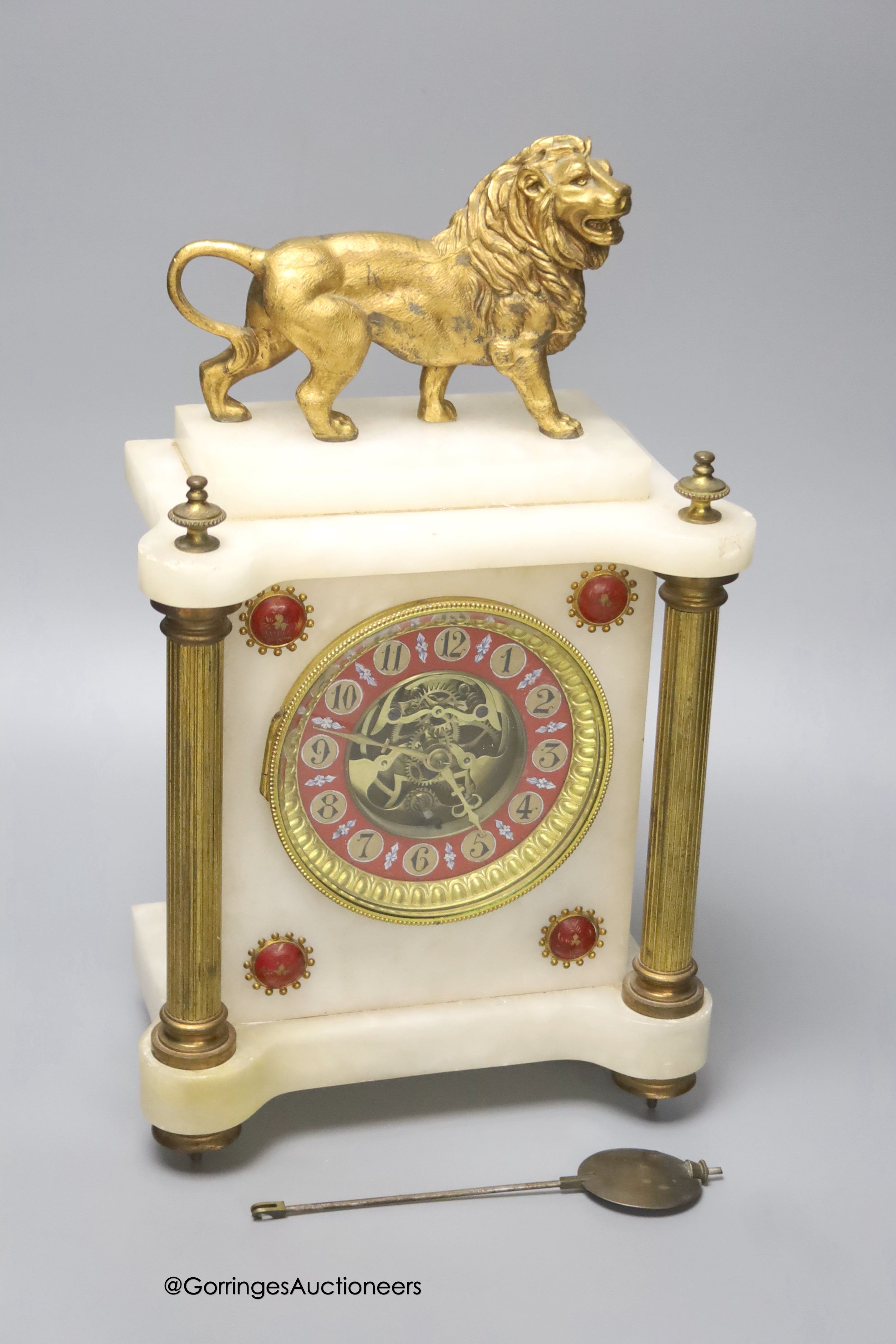 A Victorian alabaster mantel clock, with gilt metal lion surmount, French skeleton movement with pendulum, 34cm